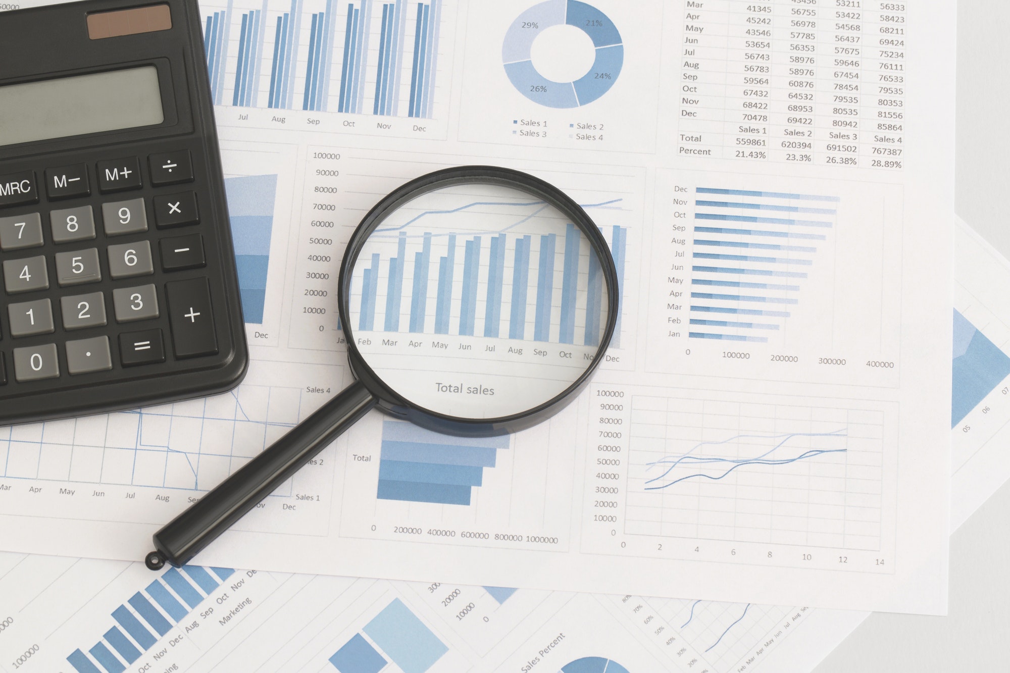 business-graphs-charts-magnifying-glass-and-calculator-on-table-financial-development.jpg